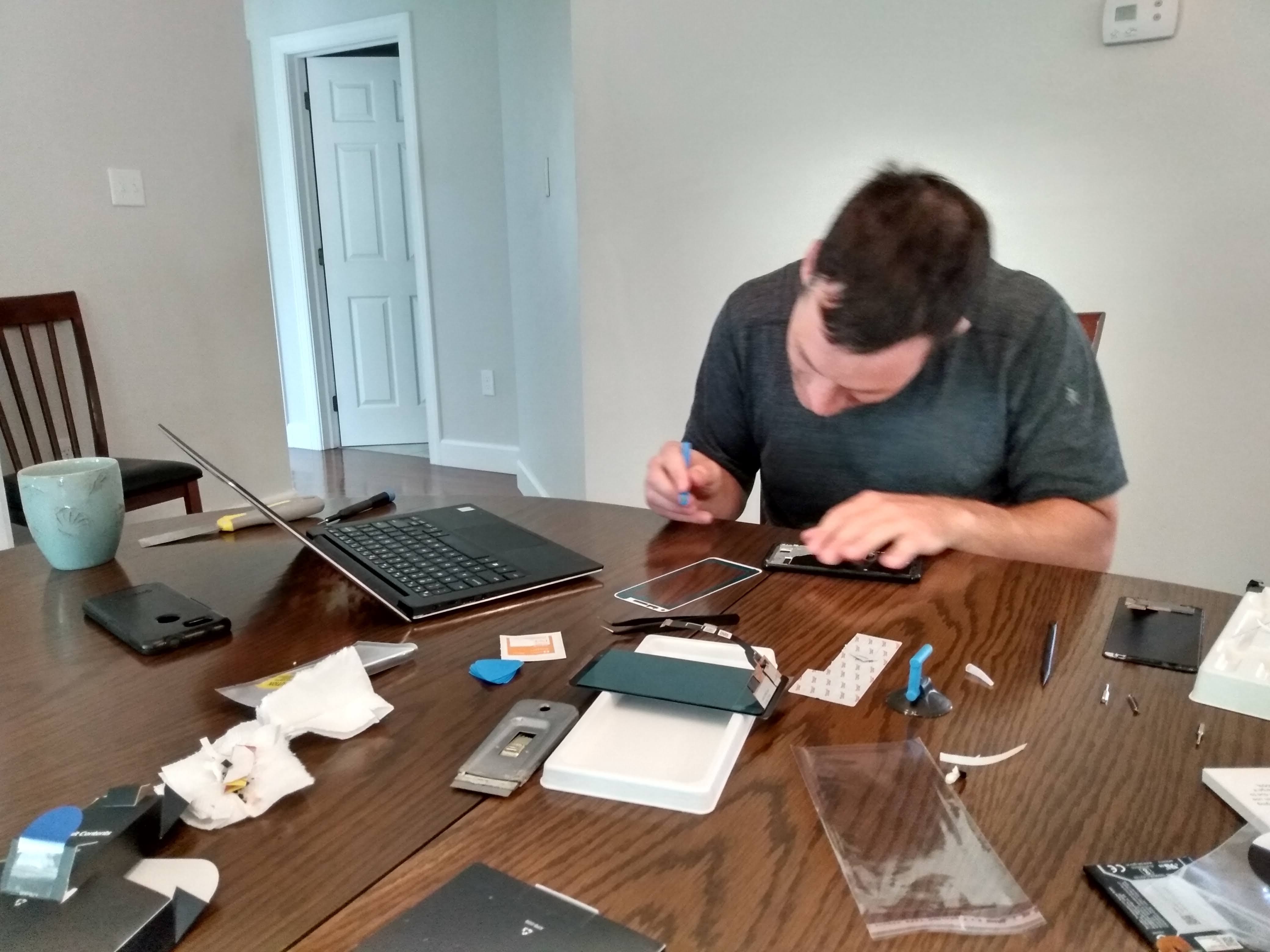 Greg working to replace the screen on his phone.